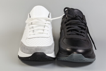 One black and one white leather classic sneaker, front view