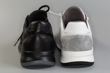 One black and one white leather classic sneaker, back view