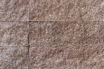 Wall faced with decorative rough rectangular gray stone tiles