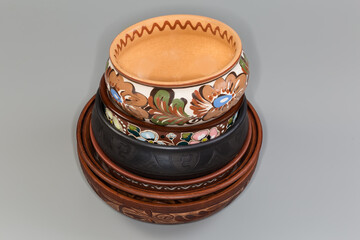 Stacked different empty clay bowls on a gray background
