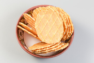 Sweet round wafers in bowl on gray background, top view