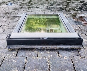 Contemporary skylight on slate roof with rainwater detail and architectural texture in overcast...
