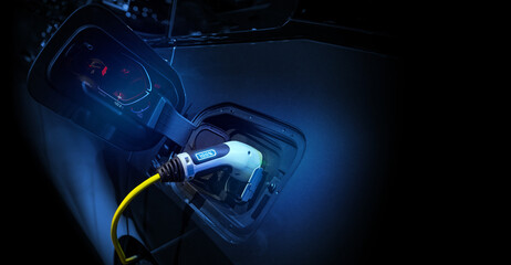 Power cable pump plug in charging power to electric vehicle EV car.