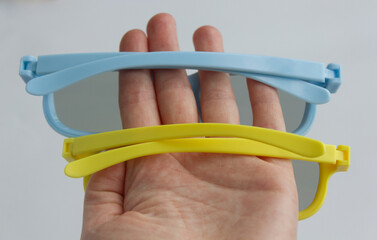yellow glasses, blue glasses, human hand, photo background, Ukraine, yellow and blue colors, flag...