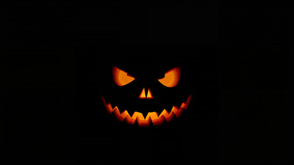 Glowing halloween pumpkin showing scary face in the dark