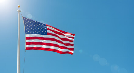 Obraz premium Side view of American flag waving in the wind against clear blue sky as a symbol of national unity