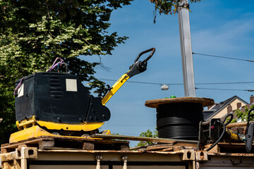 Heavy construction equipment is positioned on a wooden platform in an urban setting. The sunny day...