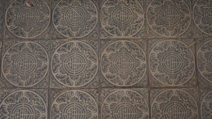 Worn stone tiles engraved with circular emblems reflect the timeless rhythm and craft of traditional spaces.
