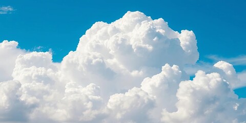 A massive, fluffy white cumulus cloud dominates a vibrant azure sky, bathed in sunlight,  cumulus,  blue