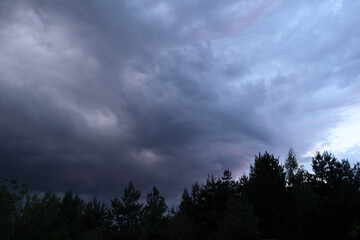 Dramatic thunderstorm with dark clouds in the evening. Dramatic cloudscape featuring dark, moody...