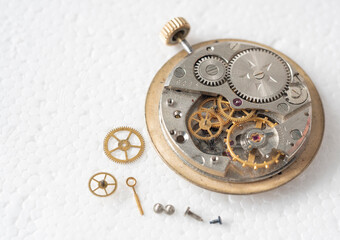 Close up of a professional watchmaker repairer working on an old vintage pocket watch in a workshop.