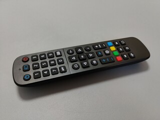 black remote control with colored buttons for television, close-up, isolated on grey background