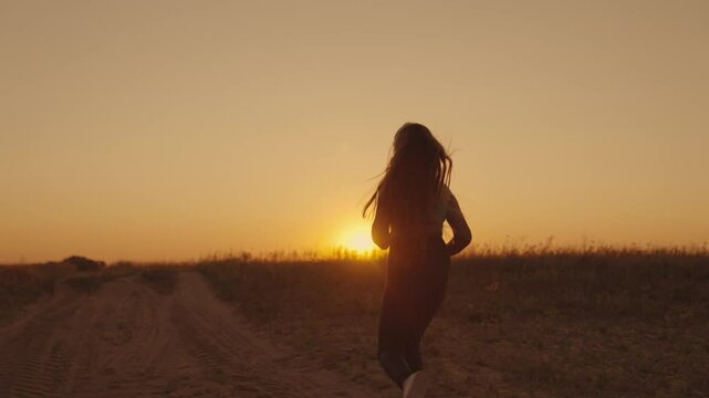 silhouette of sportive girl runs at sunset in sky outdoors, maintain healthy lifestyle with cardio workouts in sun, female fitness at dawn, morning endurance training against laziness, slow motion.