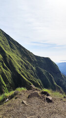 Summer mountain landscape with green grass and panoramic views of hills, trees, and sky