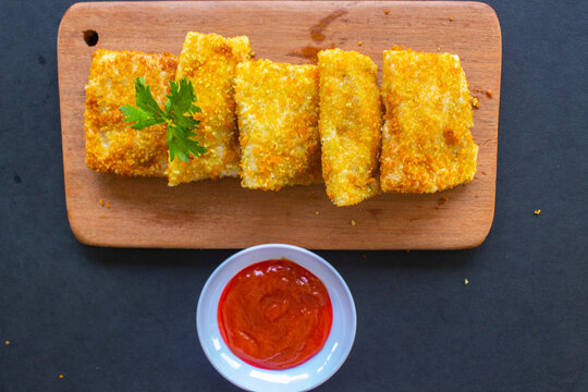 Fried Risoles or Risol Mayo are Indonesian snacks. Like Coxinha de Galinha. served with chili sauce, celery on wood board