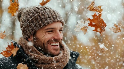 A joyful man smiles as he experiences the beauty of winter, surrounded by colorful falling leaves and snowflakes, capturing the essence of seasonal transitions.