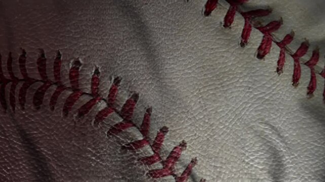 High detail close up of baseball seam with red thread on white leather. Ideal macro sports imagery for backgrounds, baseball content, athletic texture studies, or training and fan materials.