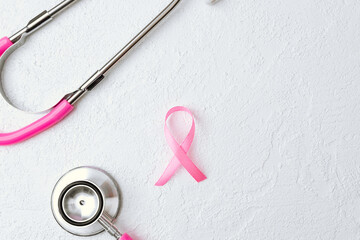 Stethoscope and ribbon on white background for breast cancer awareness