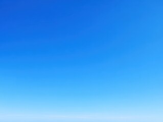 Clear blue sky with subtle gradient and distant horizon over a calm ocean