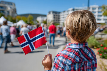 Young blond boy waving Norwegian flag, standing amid cheering crowd during national day celebration, capturing national pride and festive Norwegian spirit