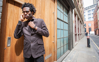 London Real Estate. A young professional estate agent closing a deal on the phone while outside the...