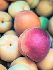 Vertical close-up of ripe red peaches on display at a farmer's market