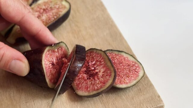 Early fig (breva) being cut on wooden table.