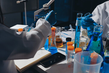 Scientist pipetting medical samples into microplate in laboratory