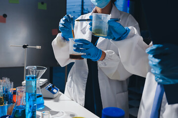 Scientist pipetting medical samples into microplate in laboratory