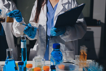 Scientist pipetting medical samples into microplate in laboratory