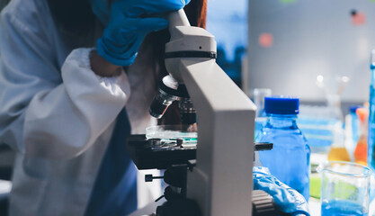 Scientist pipetting medical samples into microplate in laboratory