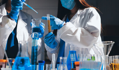 Scientist pipetting medical samples into microplate in laboratory