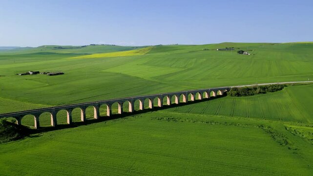 Ponte dei 21 Archi in Spinazzola, Puglia &ndash; Historic Railway Viaduct between Green Fields under Blue Sky. Italian Rural Architecture, Spring Landscape