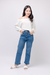 Full body portrait happy smile young asian beautiful woman curly hair wearing long sleeved shirt, blue jeans outfit, casual standing pose on white background joy positivity fashion lifestyle concept.