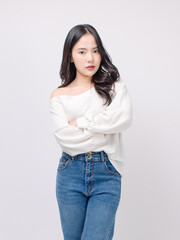 Half body portrait happy smile young asian beautiful woman curly hair wearing long sleeve shirt, blue jeans outfit, casual standing pose on white background joy positivity fashion lifestyle concept.