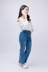 Happy cheerful young asian beautiful woman curly hair wearing long sleeved shirt blue jeans, outfit casual using mobile phone smartphone on white background in studio for social media or video call.