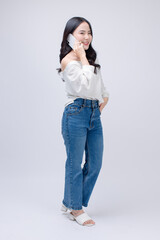 Happy cheerful young asian beautiful woman curly hair wearing long sleeved shirt blue jeans, outfit casual using mobile phone smartphone on white background in studio for social media or video call.