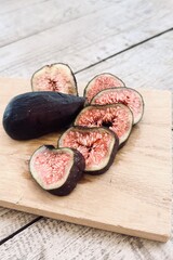 Fresh breba fig pieces on wooden board.