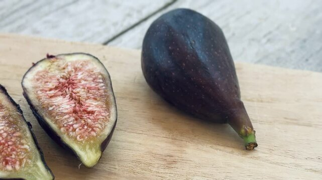 Fresh breba fig pieces on wooden board.