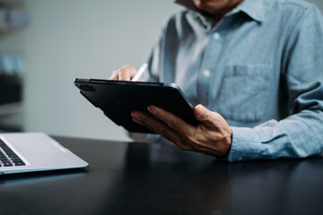 businessman using a stylus with digital tablet in office. Concept of smart technology, remote work