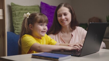 mother engaged school program home with her child digital laptop. parental assistance support...