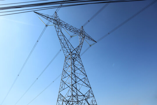 "High voltage transmission towers. the pylon outline Very High Voltage Power Lines (Indonesia : SUTET) on blue sky"
