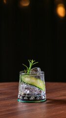 Gin tonic drink with ice and with cucumber on top