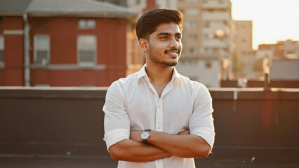 A man stands with his arms crossed wearing a white shirt, suitable for use in a variety of scenarios such as portraits, still life photography, and more
