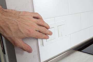 human hand in white box with white switch