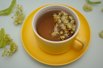 ime tea in a yellow cup with lime flowers