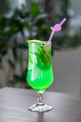 Green Lemonad with ice and a slice of lemon on top
