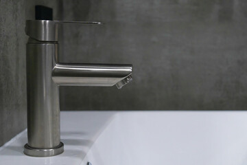 Stainless steel faucet and white ceramic sink create a stylish and functional space in a modern bathroom, showcasing contemporary design and clean aesthetics