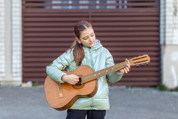 Teen Girl Playing Acoustic Guitar Outdoors