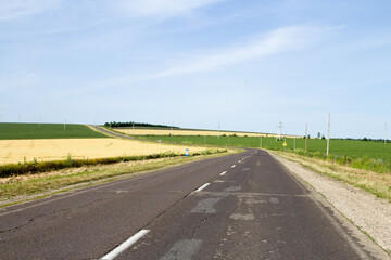 A road with grass and a blue sky